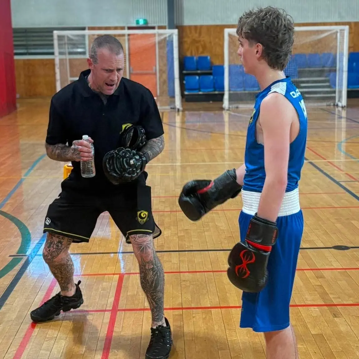 James Blair coaching a fighter on the pads