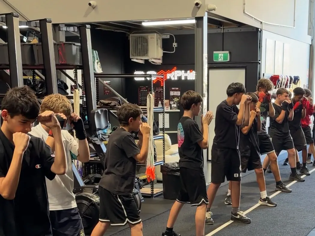 Teens in guard stance along the gym floor